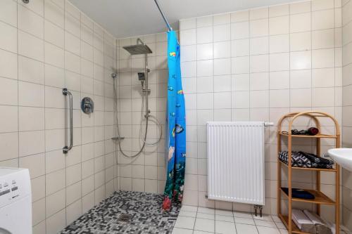 a shower with a blue shower curtain in a bathroom at Alte Schule in Münsingen