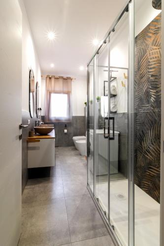 a bathroom with a glass shower and a sink at La Dimora di Luna in Terrasini