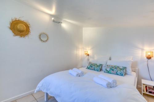 a bedroom with a white bed with towels on it at Mas des Cypres - Mazet 9 in Saintes-Maries-de-la-Mer