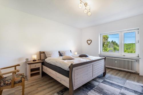 a bedroom with a large bed and a window at Ferienwohnung Auszeit Sauerland in Meinerzhagen