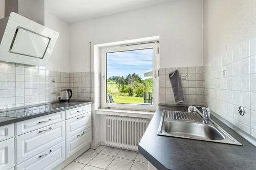 a kitchen with a sink and a window at Ferienwohnung Auszeit Sauerland in Meinerzhagen