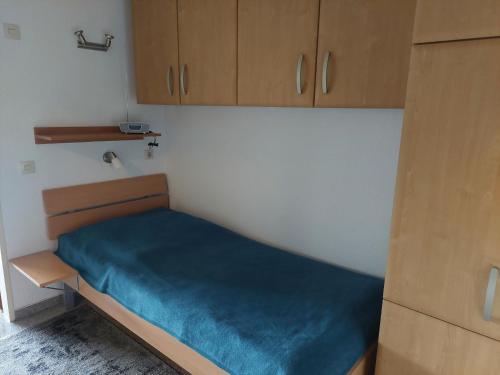 a small bedroom with a bed with a blue sheet at Ferienwohnung Sander mit Innenpool in Möhnesee