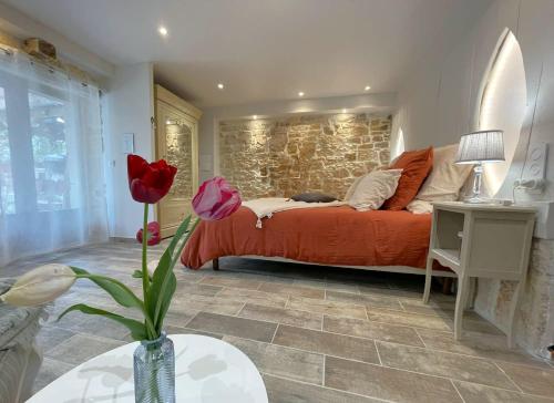 a bedroom with a bed and a brick wall at La Colombière in Salviac