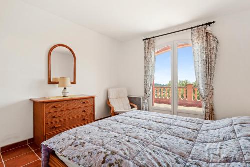 a bedroom with a bed and a dresser and a window at Villa Lucio in La Londe-les-Maures