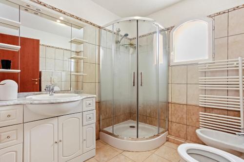 a bathroom with a shower and a toilet and a sink at Villa Lucio in La Londe-les-Maures