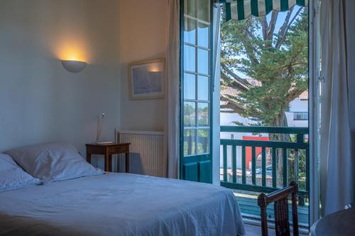 a bedroom with a bed next to a large window at Belle villa basque in Anglet