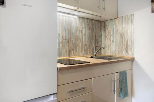 a kitchen with a sink and a counter at Bungalow Schoner Greif, Bgl 8 in Dranske