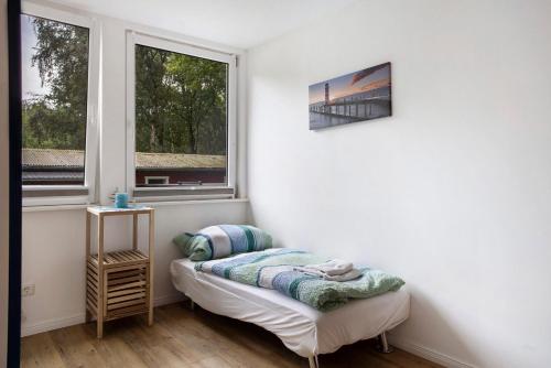 a white room with a table and two windows at Bungalow Schoner Greif, Bgl 8 in Dranske