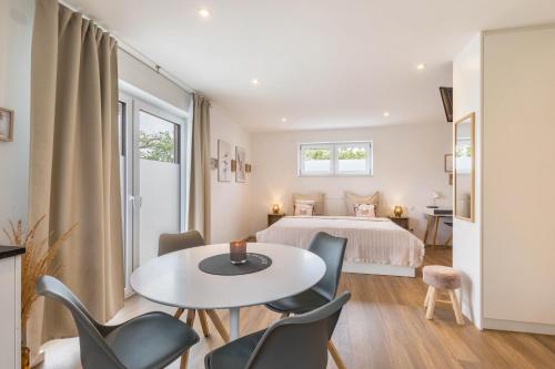 a bedroom with a bed and a table and chairs at Fewo Parkside S2 - 8Min Legoland in Günzburg