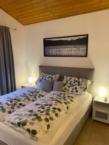 a bedroom with a large bed with two lamps on it at Glückshuuske Sauerland in Meschede