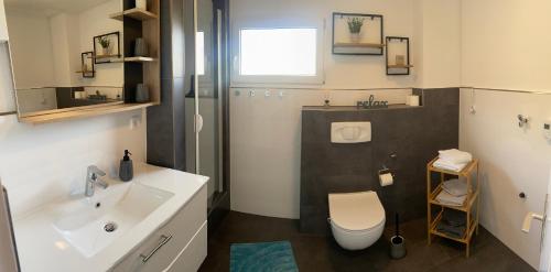 a bathroom with a white sink and a toilet at Glückshuuske Sauerland in Meschede