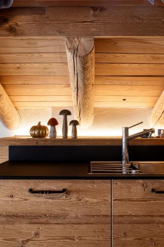 a kitchen with wooden walls and a counter with a stove at Alpine Mood Apartments in Falcade