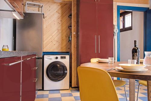a kitchen with a washing machine and a table with chairs at Cadepaia Lago Maggiore in Laveno-Mombello