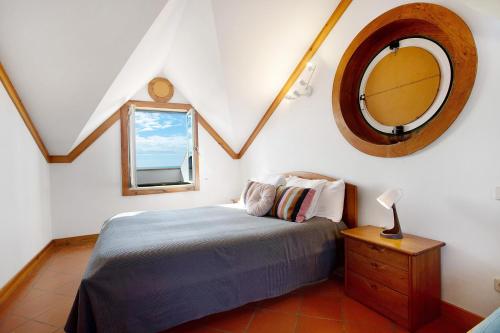 a bedroom with a bed and a mirror on the wall at A Casa da Concha in São Pedro de Moel
