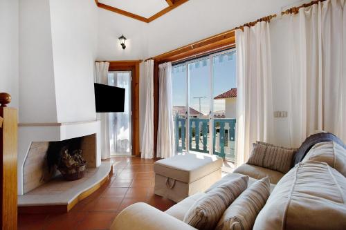 a living room with a couch and a fireplace at A Casa da Concha in São Pedro de Moel