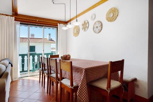 a dining room with a table and chairs and a window at A Casa da Concha in São Pedro de Moel