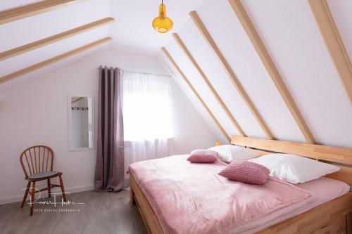 a bedroom with a bed with pink pillows on it at Ferienhaus Specht in Schotten