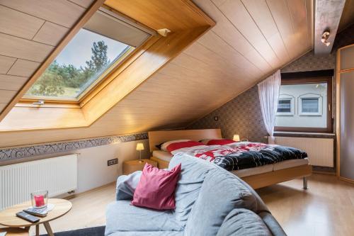 a attic bedroom with two beds and a window at Elkes Ferienappartment in Eschenrod