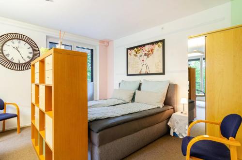 a bedroom with a bed and a clock on the wall at Ferienwohnung Refugium Nest in Sigmaringen