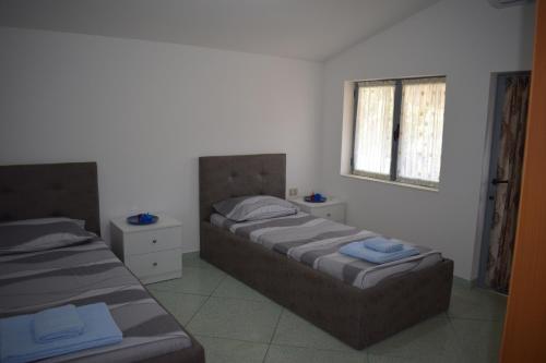 two twin beds in a room with a window at Ulza Lake Escape in Ulëz