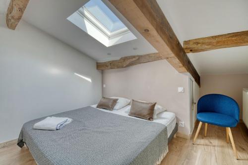 a bedroom with a bed and a blue chair at Villa Virginie gite 2 in Faudoas