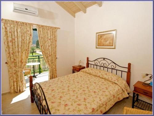 a bedroom with a bed and a balcony at Sami Beach Villas Thalia in Sami