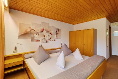 a bedroom with a white bed with two pillows at Bed and Breakfast Ederhof in San Giacomo