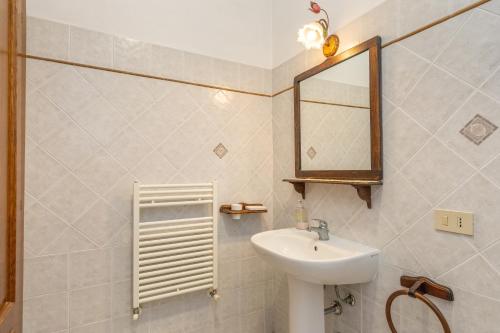 a bathroom with a sink and a mirror at La Sassetta in Bibbona
