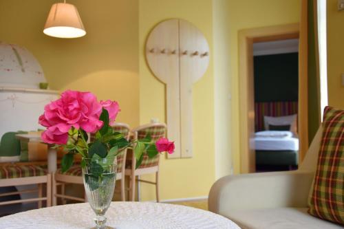 a vase with pink flowers sitting on a table at Der Ronacherfels in Weissensee