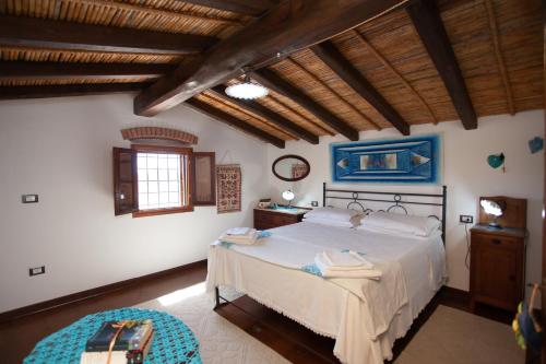 a bedroom with a large bed in a room with wooden ceilings at Sa Domedda in Orosei