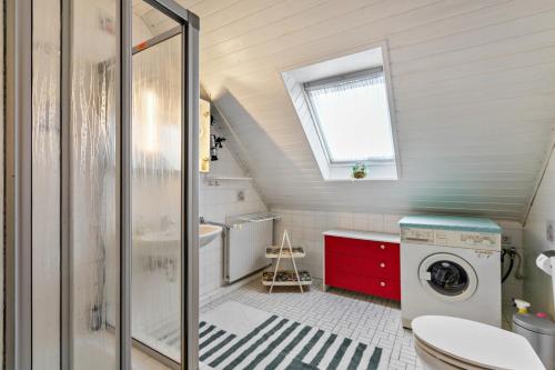 a bathroom with a toilet and a washing machine at Gästehaus Elke Jensen in Langenhorn