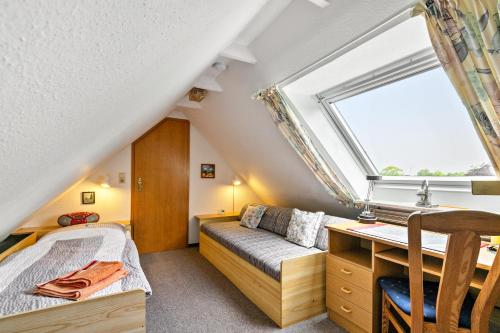 a bedroom with a bed and a desk and a window at Gästehaus Elke Jensen in Langenhorn