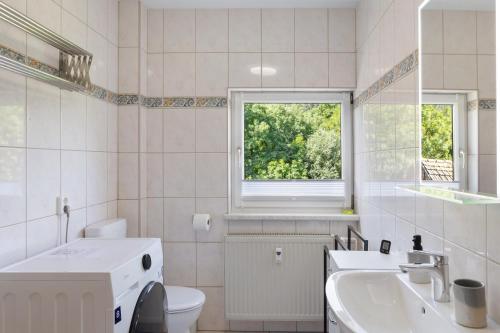 a bathroom with a sink toilet and a window at Ferienwohnung Kleinbreitenbach 2 in Plaue