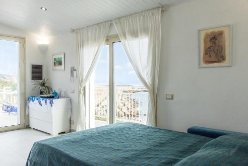 a bedroom with a bed and a large window at Sunset Dimora in Siculiana Marina