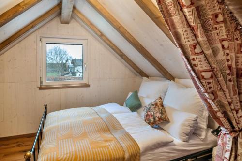 a bed in a small room with a window at Vroni in Ebersbach-Musbach