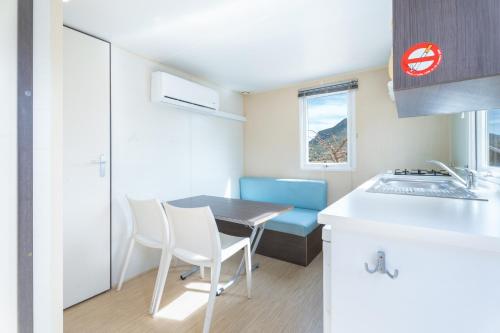 a small kitchen with a table and chairs and a sink at Falaguera Bungalow 2 in Bárig