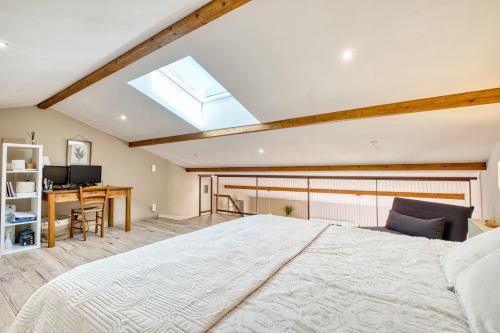 a bedroom with a large bed and a desk at Le Refuge des Vignes in Lamonzie-Saint-Martin