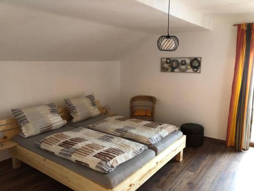 a bedroom with a wooden bed with pillows at Haus Peschl Fewo 2 in Neureichenau