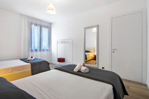 a bedroom with two beds and a mirror at Casa vacanza Guattini in Cremia