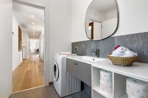 a bathroom with a sink and a washing machine at Casa vacanza Guattini in Cremia