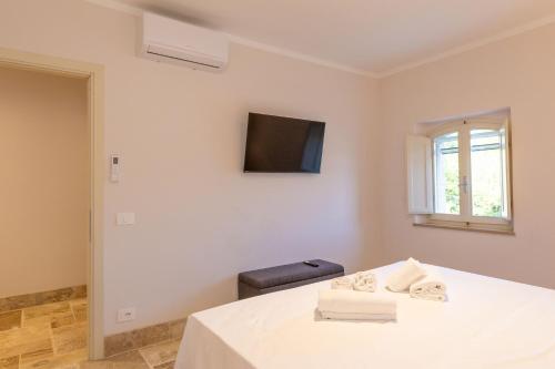 a white room with a bed and a television at Borgo Ariano near Volterra by PosarelliVillas in Volterra