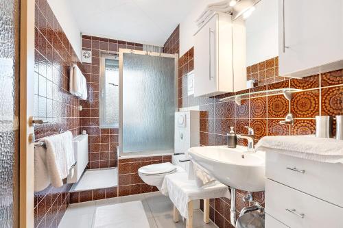 a bathroom with a sink and a toilet and a shower at Haus Erna am Deister in Barsinghausen