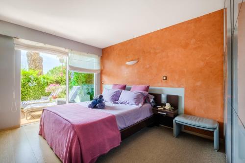 a bedroom with a large bed with an orange wall at Des vacances de rêve à Mandelieu in Mandelieu-La Napoule