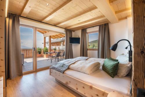 a bedroom with a bed and a balcony at Feichterhof in San Genesio Atesino