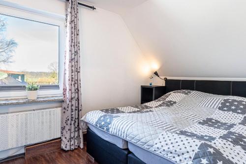 a bedroom with a bed and a window at Ferienwohnung Moin in Schönwalde am Bungsberg