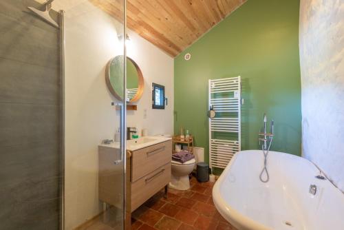 a bathroom with a tub and a sink and a toilet at Maison de vacances La Toumet in Malabat