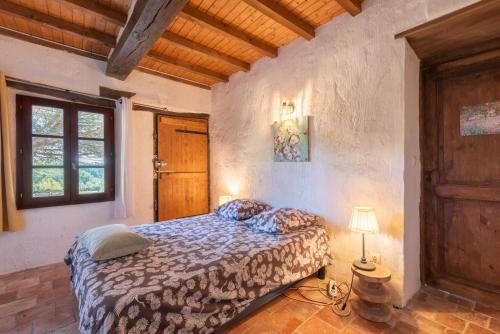 a bedroom with a bed and a window and a lamp at Maison de vacances La Toumet in Malabat