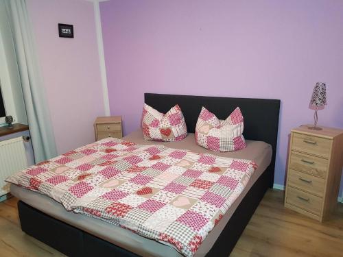 a bedroom with a bed with a quilt and pillows at Ferienwohnung Eulenhof in Templin
