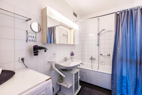 a white bathroom with a sink and a shower at Seesucht in Gaienhofen