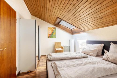 two beds in a bedroom with a wooden ceiling at Seesucht in Gaienhofen